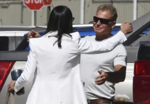 Both wearing white, Iris Eytan reaches to hug client Barry Morphew, who smiles with relief